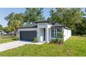 Well-manicured lawn and appealing exterior of single-Gathering home featuring modern design, a two-car garage, and lovely landscaping at 33 W 7Th St, Apopka, FL 32703