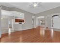 Open-concept living room featuring hardwood floors, neutral paint, and arched doorways leading to other rooms at 3304 Bennington Ct, Winter Park, FL 32792