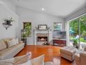 Cozy living room featuring a stone fireplace, hardwood floors, and a sliding door to the backyard at 3518 Edlingham Ct, Belle Isle, FL 32812