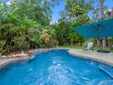Inviting private pool with lush tropical landscaping, a patio area, and an umbrella for shade at 3518 Edlingham Ct, Belle Isle, FL 32812