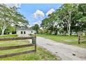 Long private gravel driveway surrounded by mature trees and lush greenery at 455 Orange Ave, St Cloud, FL 34769