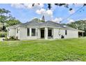 Welcoming single-story home with lush lawn, black-framed windows, and a charming front porch at 455 Orange Ave, St Cloud, FL 34769
