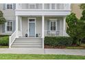 Inviting front porch with gray stairs, trimmed bushes, stylish blue door and shutters, and well manicured lawn at 5303 Brady Ln, Orlando, FL 32814