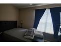 Comfortable bedroom with a large window providing natural light and dark curtains at 6316 Raleigh St # 401, Orlando, FL 32835