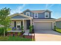 Charming two-story home with a covered front porch and a well-manicured lawn at 700 Trotters Dr, Eagle Lake, FL 33839
