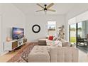 Bright living room with a sectional sofa, TV, decor, and large windows bringing in natural light at 701 Dennis Ave, Orlando, FL 32807