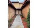 Exterior view of pathway between units with landscaped mulch beds and matching doors at 707 Carpenters Way # 50, Lakeland, FL 33809