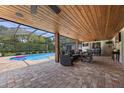 Covered patio with comfortable seating, overlooking the pool and private backyard oasis at 8655 Shady Glen Dr, Orlando, FL 32819