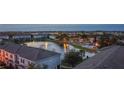 Scenic aerial view of the neighborhood at dusk featuring a pond with fountain, manicured landscaping, and community buildings at 10914 Savannah Wood Dr # 139, Orlando, FL 32832