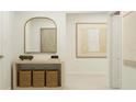 Bright entryway with a decorative mirror, wood console table, baskets, and light neutral decor at 1277 Deepwater Cir, Eagle Lake, FL 33839
