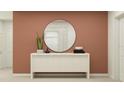Staged entryway featuring a round mirror, neutral console table, and minimalist decor at 1277 Deepwater Cir, Eagle Lake, FL 33839