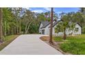 A long, winding driveway leading to a modern white house with a two-car garage at 1394 Kettledrum Trl, Deltona, FL 32725