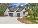 Side view of a modern two-car garage with gray doors and exterior lighting fixtures at 1394 Kettledrum Trl, Deltona, FL 32725