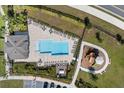 Aerial view of community pool, playground, ample lounge seating, and parking at 1401 Mirabella Cir, Davenport, FL 33897