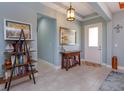 Inviting entryway with tile flooring, soft blue walls, stylish console table, decorative shelving, and lots of natural light at 14830 Winkfield Ct, Winter Garden, FL 34787