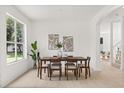 Sunlit dining area features a contemporary table set and neutral decor at 14927 Faversham Cir, Orlando, FL 32826