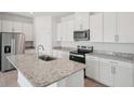 Well-equipped kitchen featuring granite countertops, sleek stainless steel appliances, and white cabinets at 2089 Rosewood Dr, Bartow, FL 33830