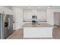 Modern kitchen featuring white cabinets, granite countertops, stainless steel appliances, and a large center island at 2089 Rosewood Dr, Bartow, FL 33830