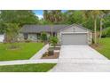 Charming single-story home with stone accents, manicured lawn, and two-car garage on a sunny day at 2901 Autumnwood Trl, Apopka, FL 32703