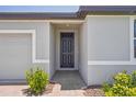Close-up of a stylish black front door with brick walkway, and manicured front yard at 3210 Viceroy Ct, Poinciana, FL 34759