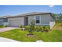 New home featuring a well-maintained lawn and complementary landscaping at 3210 Viceroy Ct, Poinciana, FL 34759