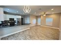 Sunlit living area featuring an open floor plan, modern lighting, and wood-look tile at 344 Buenaventura Blvd, Kissimmee, FL 34743