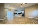 Open-concept living and kitchen area with light-toned walls and wood-look tile flooring at 344 Buenaventura Blvd, Kissimmee, FL 34743