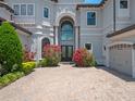 Luxury home features a grand entrance with a brick driveway and manicured flowerbeds at 4071 Isabella Cir, Windermere, FL 34786