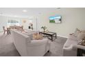 Bright living room features neutral walls, plush carpeting, comfortable sofas, and natural light from the dining area at 440 Patricia Alford Dr, Haines City, FL 33844
