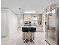 Bright kitchen with tiled floors, stainless steel refrigerator, and center island with seating at 4546 Malibu St, Orlando, FL 32811