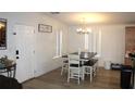 Bright dining area featuring a modern chandelier, large windows, and stylish wood flooring at 5054 Mcdonald Rd, Zellwood, FL 32798
