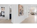 Bright hallway featuring tile floors, white walls and views of a bedroom and living room at 7420 Ivy Tendril Ave, Orlando, FL 32829