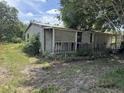 Exterior side view of home with screened porch and overgrown yard at 749 Saddlewood Blvd, Lakeland, FL 33809