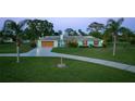 Single-story home with a well-manicured lawn, mature palms, and a spacious driveway at 775 Bay Dr, New Smyrna Beach, FL 32168