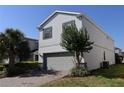 Charming two-story home featuring a well-manicured lawn and lush landscaping at 8930 Zurich Ln, Kissimmee, FL 34747