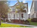 Exterior shot of a white two-story home featuring a quaint porch, professional landscaping and blue sky at 9425 Holliston Creek Pl, Winter Garden, FL 34787
