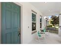 Charming front porch featuring a rocking chair and a vibrant blue front door at 9425 Holliston Creek Pl, Winter Garden, FL 34787