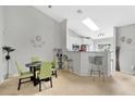 Bright dining area with modern table, chairs, and bar seating, complemented by a skylight and open kitchen at 9616 River Walk Ct, Orlando, FL 32825
