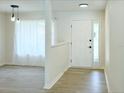 Bright entryway featuring neutral paint, wood-look flooring, and a front door with sidelight window at 965 Brentwood Dr, Apopka, FL 32712