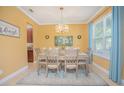 Elegant dining room with a stylish chandelier, dining set for six, and blue accent rug at 10520 Burrows St, Orlando, FL 32832