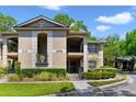 Exterior shot of a two-story condo building with well-maintained landscaping and private balconies at 1074 Kensington Park Ct # 101, Altamonte Springs, FL 32714