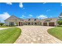 Beautiful front exterior with circular driveway, meticulous landscaping, and a three-car garage at 10845 Bayshore Dr, Windermere, FL 34786