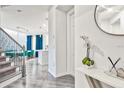 Bright entryway features wood-look floors, staircase with metal railing, and view of the dining and kitchen at 1147 Wildmeadow Run, Winter Park, FL 32792
