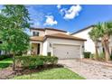 Charming two-story home featuring a tile roof, neutral stucco exterior, and a brick paver driveway at 1147 Wildmeadow Run, Winter Park, FL 32792