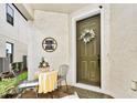 Welcoming front porch featuring decorative sign, seating, and a charming front door with floral wreath at 1147 Wildmeadow Run, Winter Park, FL 32792