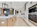 Kitchen and island with stainless appliances, island seating, tile backsplash, and under cabinet lighting at 13791 Abberwick Dr, Orlando, FL 32832