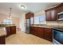 Well-lit kitchen with granite countertops, stainless steel appliances, and dark wood cabinets at 1470 Winston Rd, Maitland, FL 32751