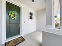 Inviting entryway with a decorative wreath on the front door and a welcome mat at 15865 Bradicks Ct, Clermont, FL 34711