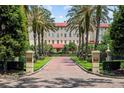 Scenic view of the building entrance, highlighted by palm trees and manicured landscaping at 1602 Alabama Dr # Ph404, Winter Park, FL 32789