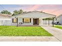 Beautiful single-story home featuring a covered front porch with a swing, lush lawn, and covered carport at 1623 Cumbie Ave, Orlando, FL 32804